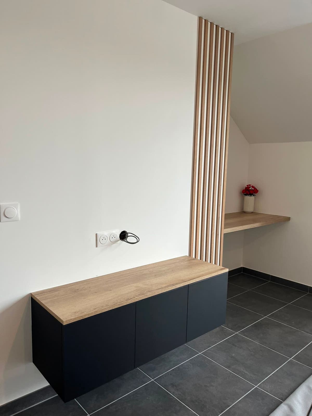 Console suspendue noire à plan bois, prolongée par un claustra et un bureau sur mesure